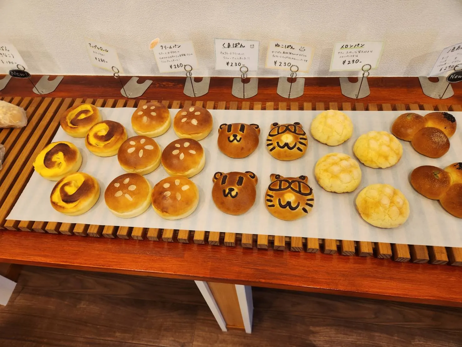 くまやねこの顔のパン、メロンパンなどが並ぶ店内の一角