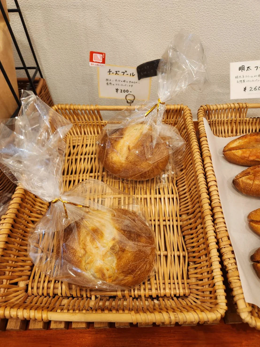 籐のかごに入った、袋入りの丸いチーズブール
